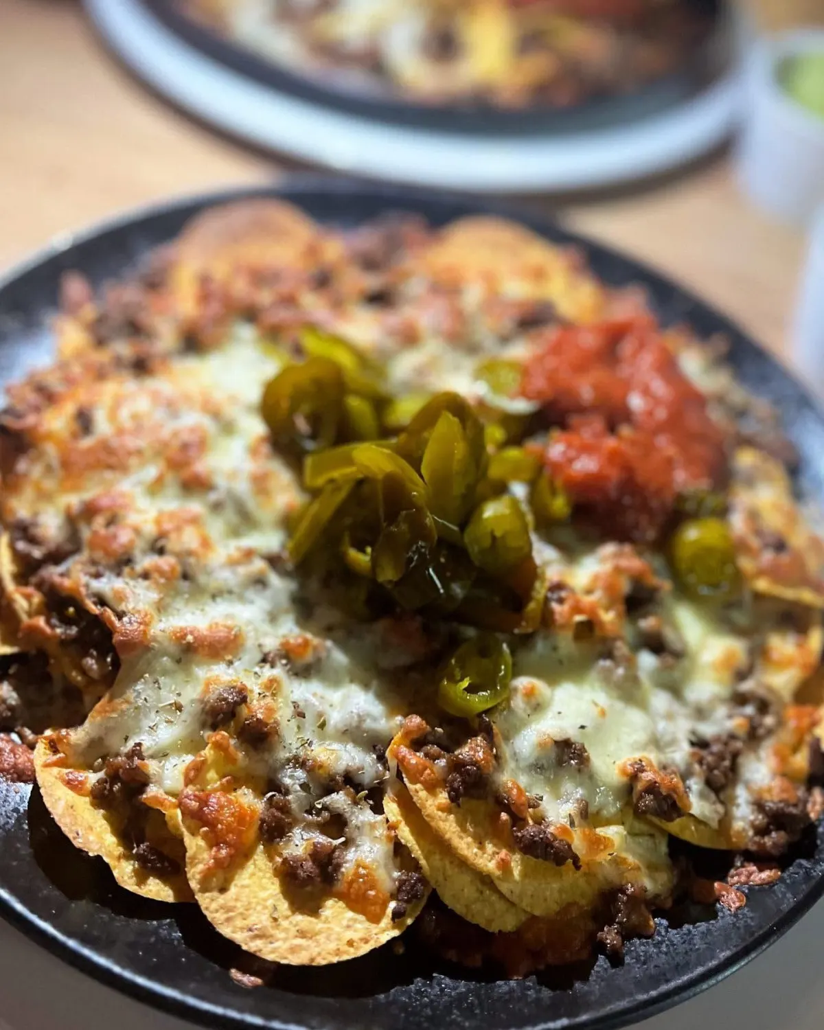Husets nachos-tallerken med jalapeños og salsa